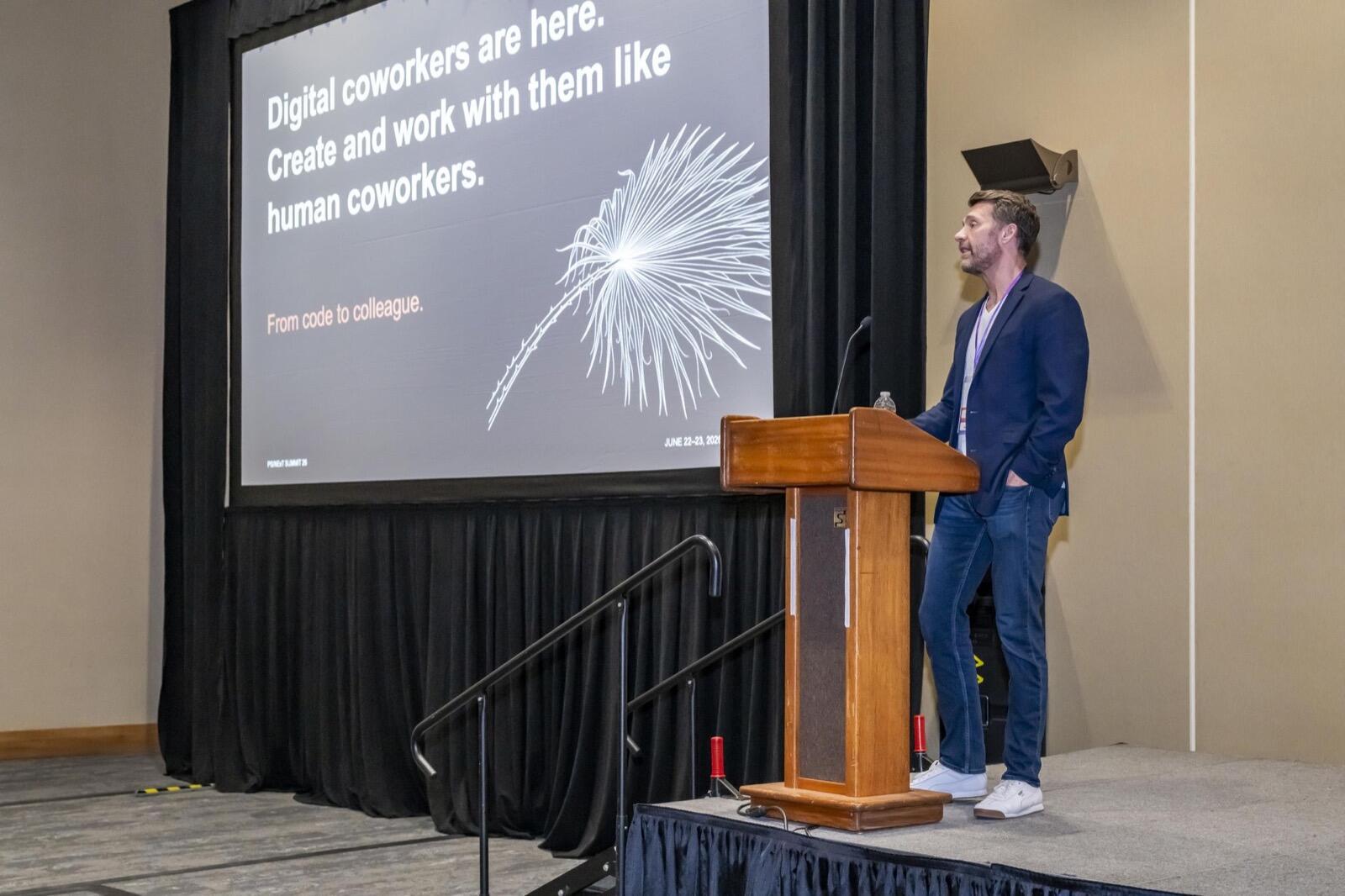 Travis McBurney at PS-NeXT Summit presenting 'Digital coworkers are here' slide